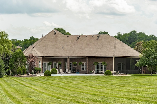 rear view of property with a yard and a patio