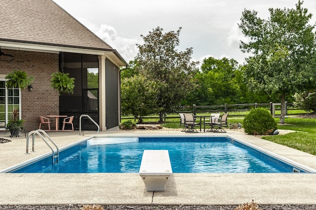 view of swimming pool featuring a diving board and a patio area