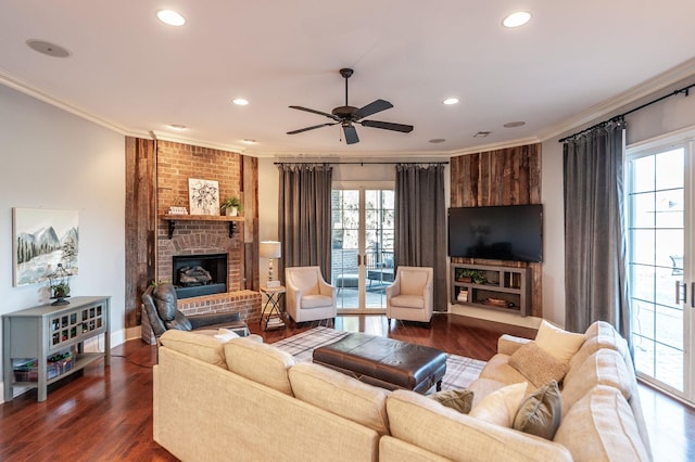 living room featuring a brick fireplace, ornamental molding, dark hardwood / wood-style floors, and ceiling fan