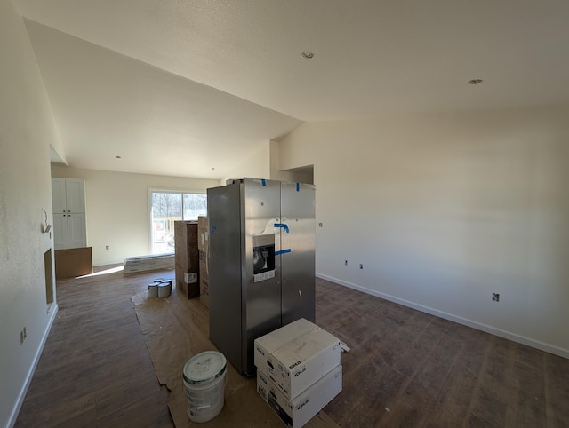 kitchen featuring dark wood-style flooring, baseboards, white cabinets, vaulted ceiling, and stainless steel fridge with ice dispenser