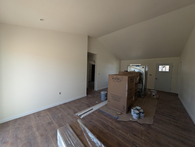 unfurnished living room with lofted ceiling, wood finished floors, and baseboards