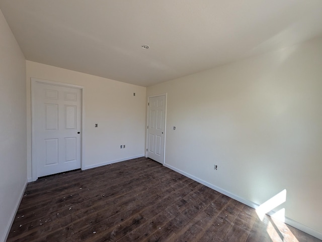 unfurnished bedroom featuring dark wood-style floors and baseboards