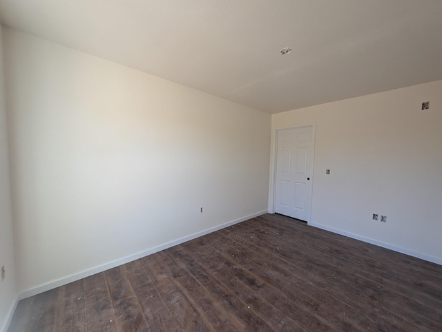 empty room with baseboards and dark wood-style flooring