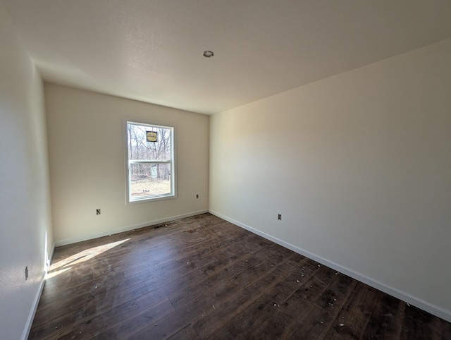 empty room with dark wood-style floors and baseboards