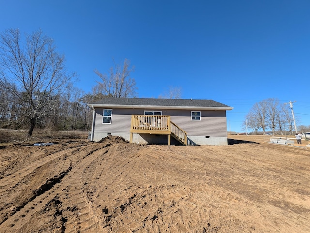 rear view of house with a deck, stairway, and crawl space