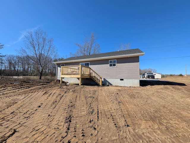 rear view of property featuring crawl space, stairway, and a deck