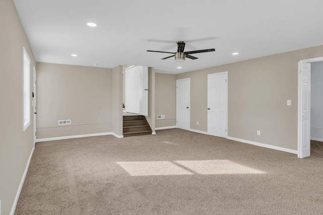 carpeted spare room featuring ceiling fan