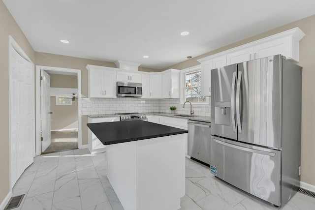 kitchen featuring sink, white cabinetry, tasteful backsplash, a kitchen island, and stainless steel appliances