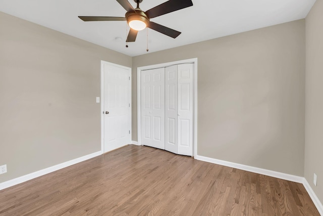 unfurnished bedroom with light hardwood / wood-style flooring, a closet, and ceiling fan