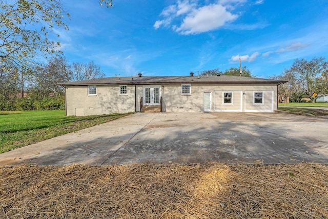 rear view of property featuring a patio, a yard, and french doors