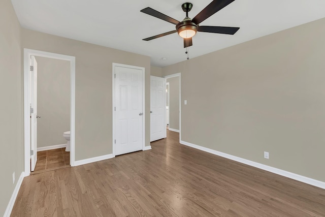 unfurnished bedroom with connected bathroom, ceiling fan, and light hardwood / wood-style flooring