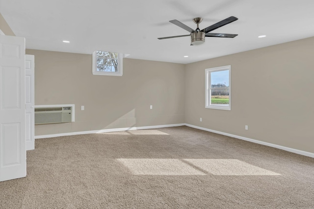 carpeted spare room featuring ceiling fan, a healthy amount of sunlight, and a wall mounted AC