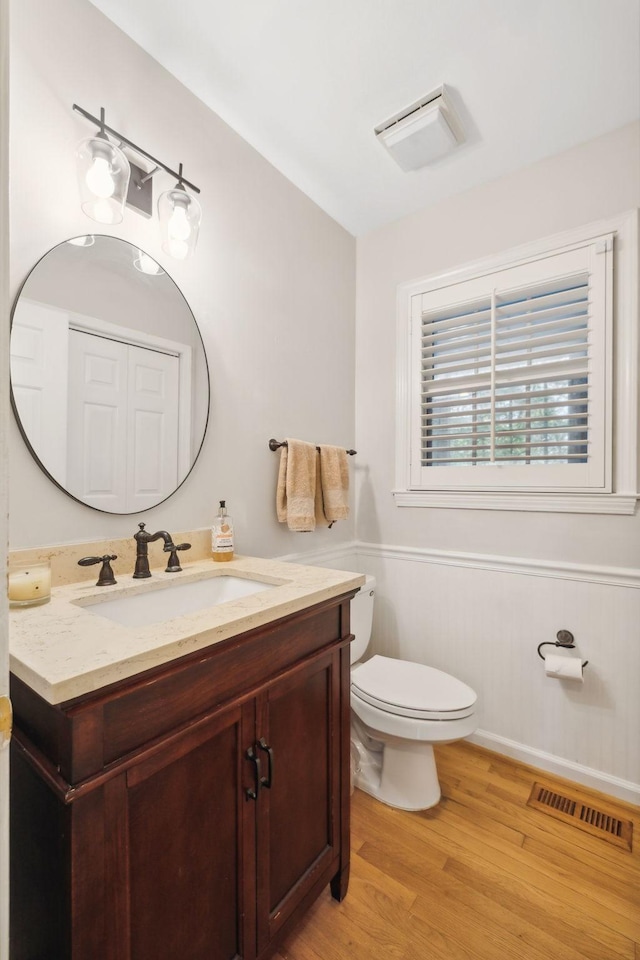 bathroom with wood-type flooring, vanity, and toilet