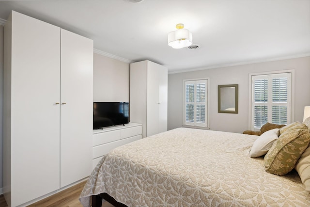 bedroom with light hardwood / wood-style flooring and ornamental molding