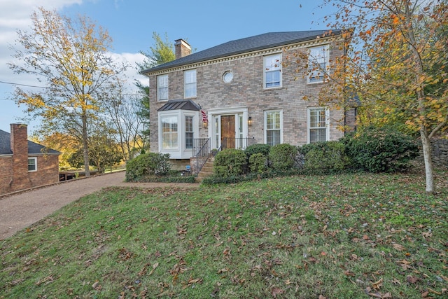 colonial-style house with a front lawn