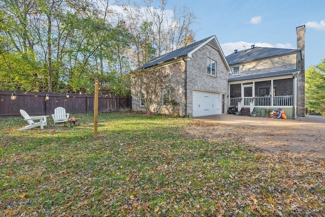 exterior space with a garage, a front yard, and a sunroom