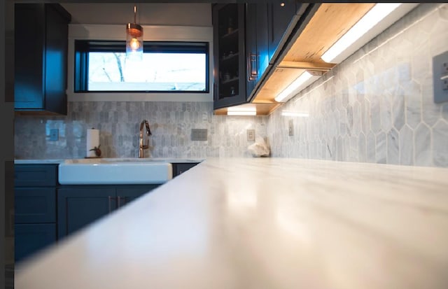 kitchen featuring pendant lighting, sink, and backsplash