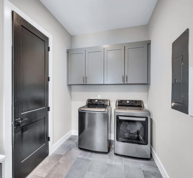 washroom featuring cabinets, washer and dryer, and electric panel