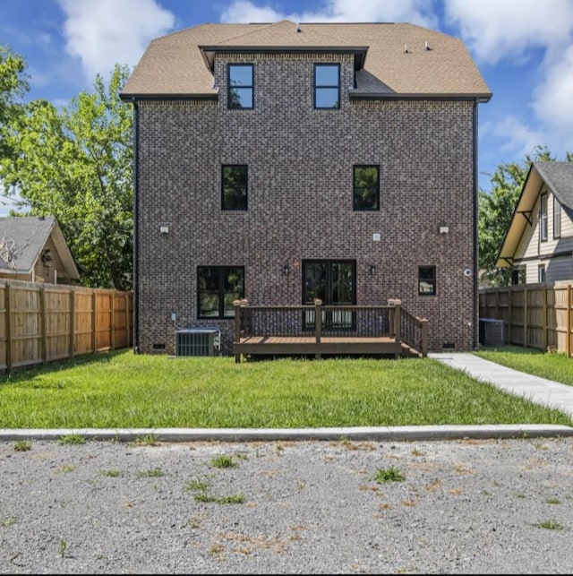 back of house with a wooden deck, central AC unit, and a lawn