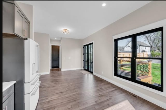 kitchen featuring dark hardwood / wood-style flooring, gray cabinets, and white fridge with ice dispenser