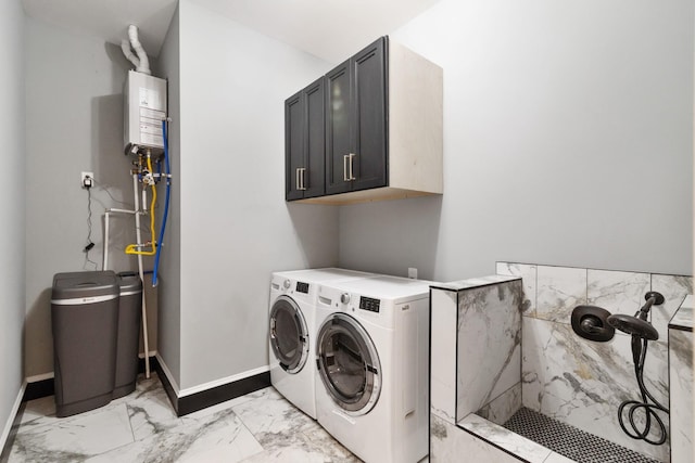 laundry area featuring cabinets, water heater, and washer and dryer