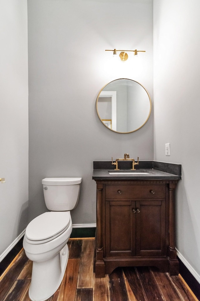 bathroom featuring vanity, wood-type flooring, and toilet