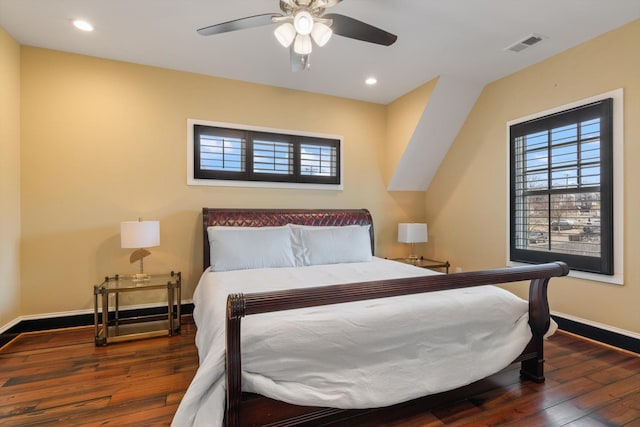 bedroom featuring multiple windows, dark hardwood / wood-style floors, and ceiling fan