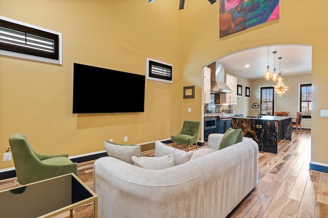 living room featuring a chandelier, sink, and light wood-type flooring