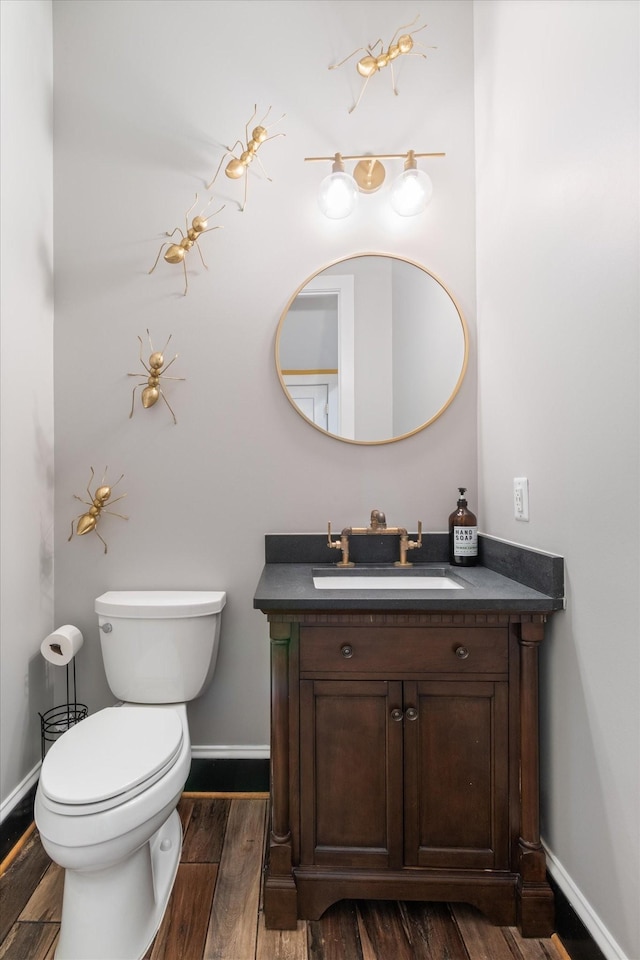 bathroom featuring wood-type flooring, toilet, and vanity