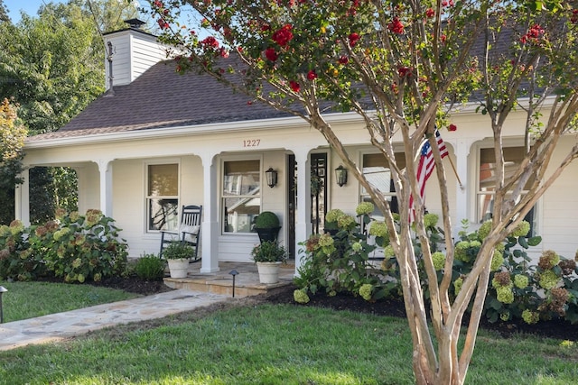 view of front of property with covered porch and a front lawn