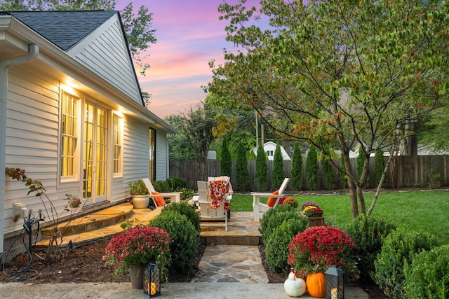 yard at dusk featuring a patio