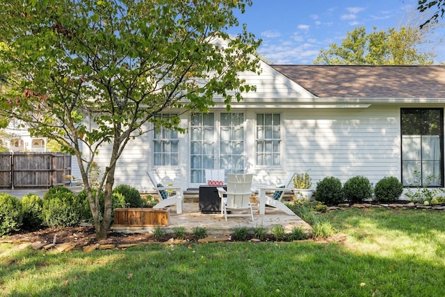 rear view of house featuring a patio and a yard