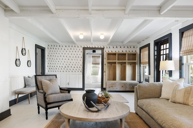 living room with beam ceiling and concrete floors