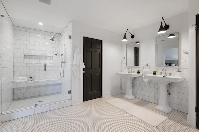 bathroom with tile patterned flooring, double sink, and walk in shower