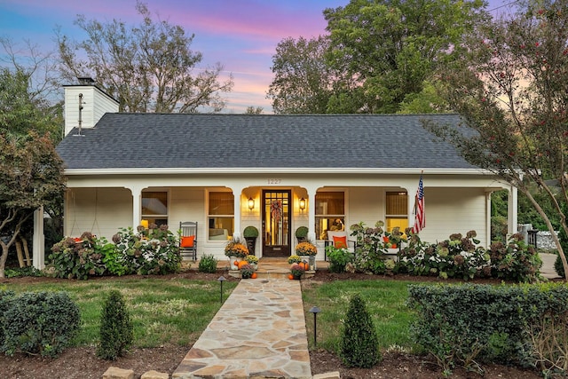 view of front of property featuring a yard and covered porch