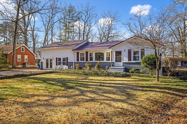 rear view of house featuring central AC unit and a yard