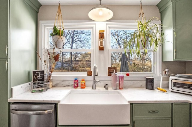 kitchen with sink, stainless steel dishwasher, green cabinets, and pendant lighting