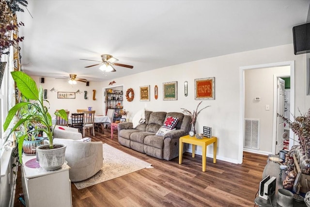 living room featuring wood-type flooring and ceiling fan