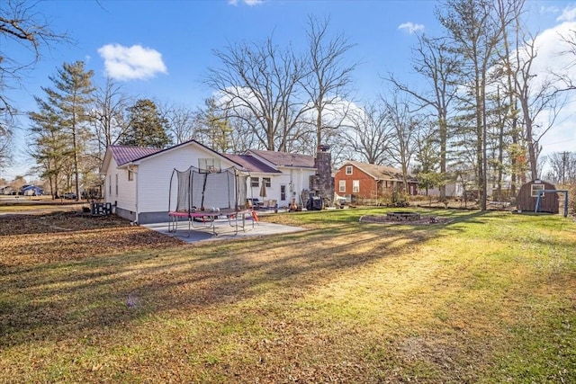 view of yard with a trampoline, a storage shed, and a patio