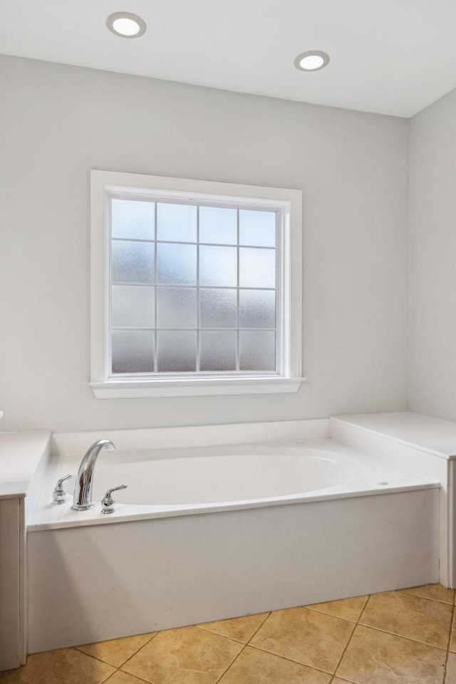 bathroom with a bath, a wealth of natural light, and tile patterned floors