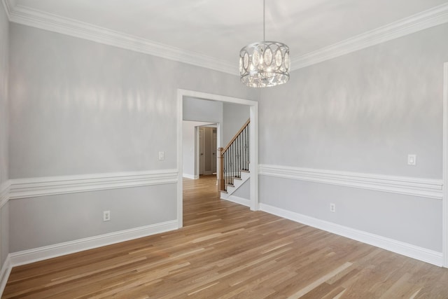 unfurnished room with crown molding, an inviting chandelier, and light hardwood / wood-style floors