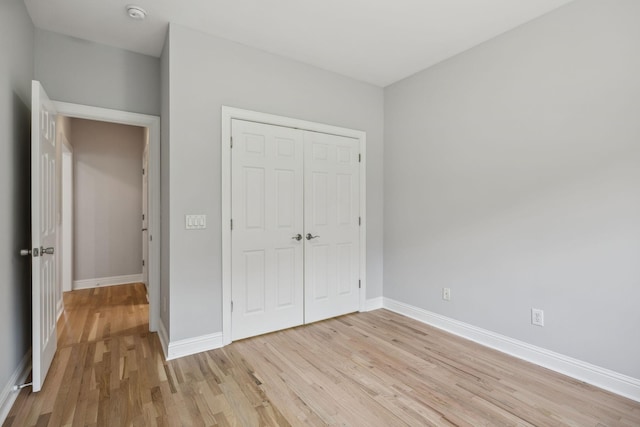 unfurnished bedroom featuring a closet and light wood-type flooring