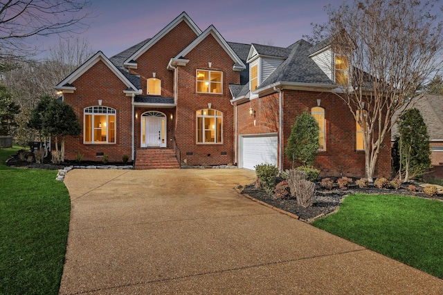 front facade featuring a garage and a lawn