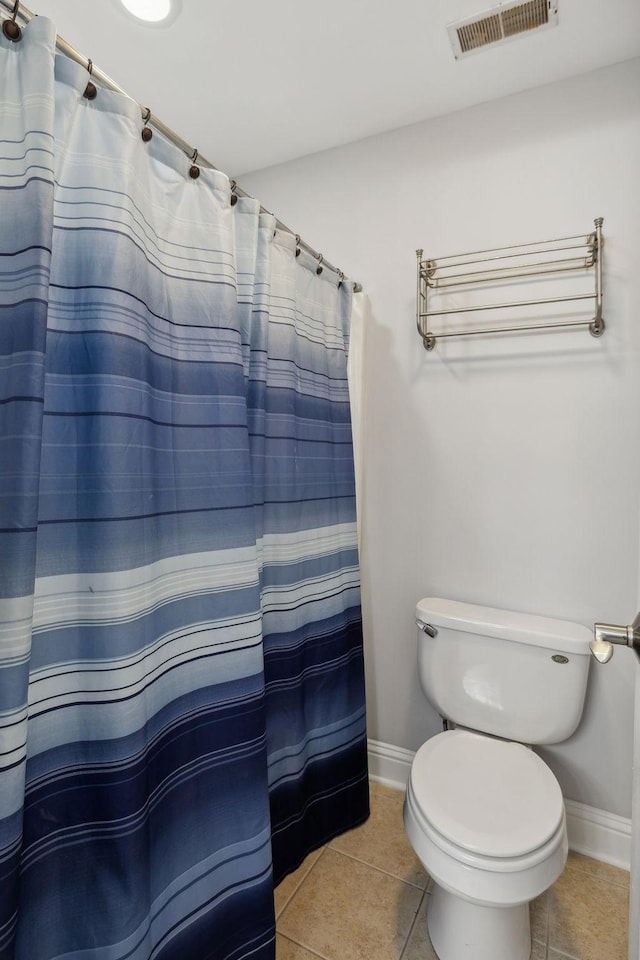 bathroom featuring walk in shower, toilet, and tile patterned flooring