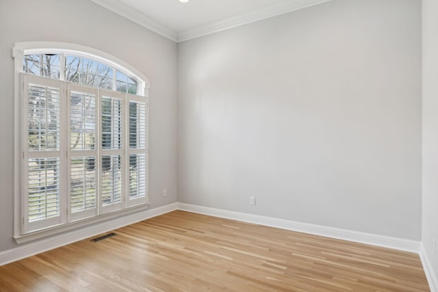 spare room with ornamental molding and light wood-type flooring