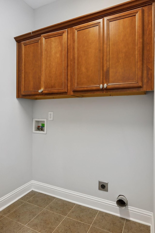 laundry room featuring cabinets, hookup for an electric dryer, dark tile patterned flooring, and hookup for a washing machine