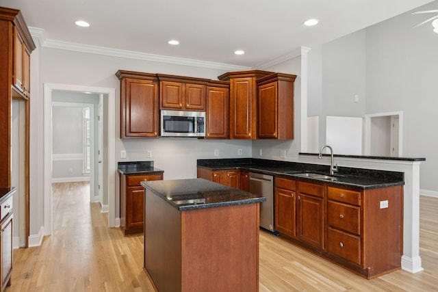 kitchen with a center island, appliances with stainless steel finishes, sink, and dark stone countertops