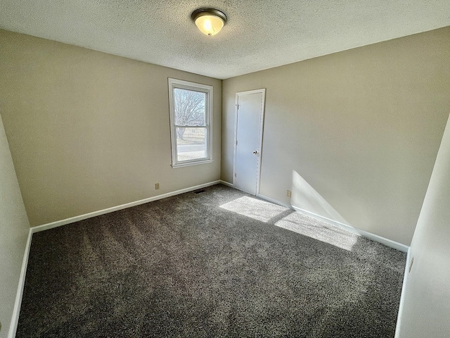 carpeted empty room with a textured ceiling