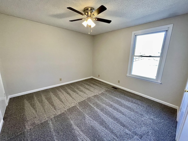 empty room with ceiling fan, carpet, and a textured ceiling