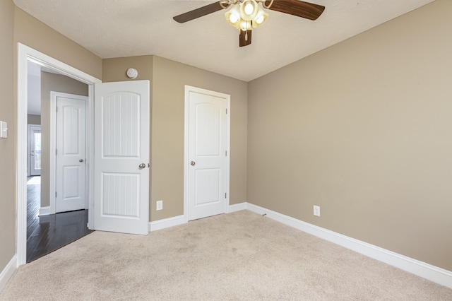 unfurnished bedroom with light colored carpet, ceiling fan, and a closet